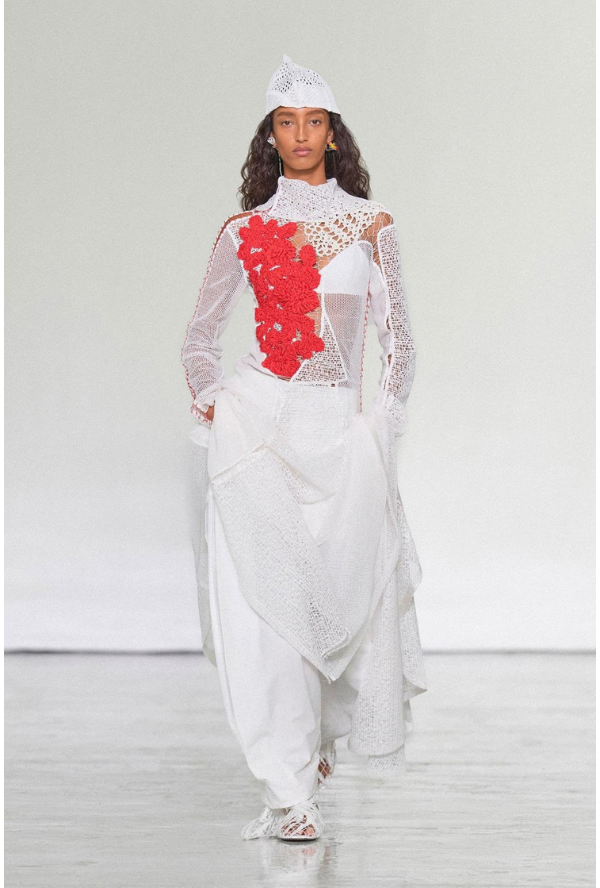 Auch Forster Willi ist mit zwei Entwicklungen in der Kollektion vertreten. Look 36 kombiniert ein rotes Soutache-Blumenallover mit verschiedenen Guipure-Netzen und bringt florale Formen mit grafischen Strukturen zusammen. Look 37 rückt die Guipure selbst in den Mittelpunkt. Unterschiedliche Netzstruktu-ren werden miteinander kombiniert und erzeugen eine abwechslungsreiche, vielschichtige Oberfläche.